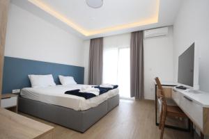 a bedroom with a bed and a desk and a television at Vile MonteMar in Herceg-Novi