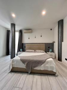 una camera con un grande letto e un pavimento in legno di Case vacanza le vele a Desenzano del Garda
