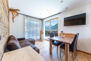 a living room with a table and a couch at Chalet Berna in Ortisei