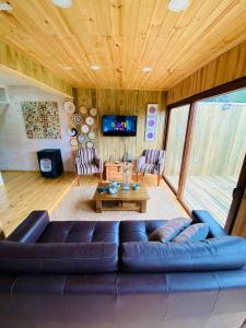 a living room with a couch and a table at forest house - a pasos del mar in Pichilemu
