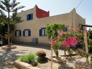 ein Gebäude mit rosa Blumen davor in der Unterkunft maison calme et reposante in Essaouira