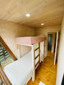 una piccola camera con 2 letti a castello in una cabina di forest house - a pasos del mar a Pichilemu
