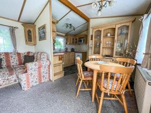 a kitchen and living room with a table and a couch at Superb Caravan With Decking At Southview Holiday Park Ref 33093s in Skegness