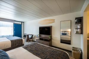 a hotel room with a bed and a flat screen tv at The Forum in Ocean City +111 photos