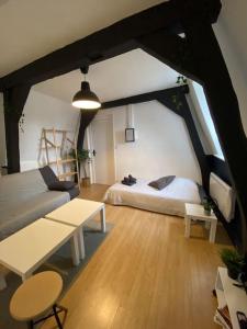 ein Wohnzimmer mit einem Bett und einem Tisch in der Unterkunft La Maison Sévigné - Appart Hôtel - N°5 in Béthune