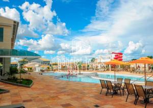 a pool at a resort with chairs and umbrellas at Lacqua Di Roma - O apartamento dos seus sonhos com desconto especial! in Caldas Novas