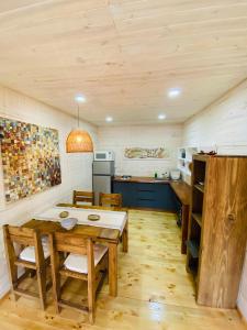 a kitchen and dining room with a wooden table at forest house - a pasos del mar in Pichilemu