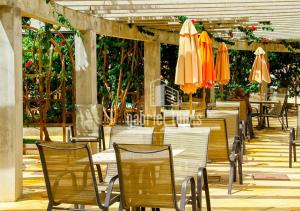 an outdoor restaurant with tables and chairs with umbrellas at Lacqua Di Roma - O apartamento dos seus sonhos com desconto especial! in Caldas Novas