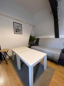 a living room with a white table and a couch at La Maison Sévigné - Appart Hôtel - N°5 in Béthune