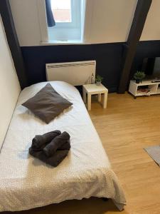 ein Schlafzimmer mit einem Bett und einem Handtuch darauf in der Unterkunft La Maison Sévigné - Appart Hôtel - N°5 in Béthune