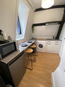 eine Küche mit einer Spüle und einer Theke mit einer Mikrowelle in der Unterkunft La Maison Sévigné - Appart Hôtel - N°5 in Béthune