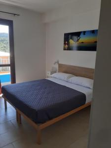 Schlafzimmer mit einem Bett mit blauer Matratze in der Unterkunft Eliseo's rooms in Triei
