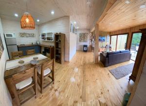 a kitchen and living room with a wooden floor at forest house - Cabaña para 4 in Pichilemu
