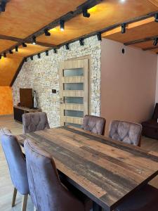 uma grande mesa de madeira num quarto com cadeiras de couro em Motel pizzeria Actros em Nova Topola