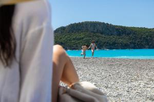 un grupo de personas sentadas en una playa en Borgo di Fiuzzi Resort & SPA, en Praia a Mare