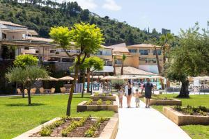 un grupo de personas caminando por una acera en un parque en Borgo di Fiuzzi Resort & SPA, en Praia a Mare