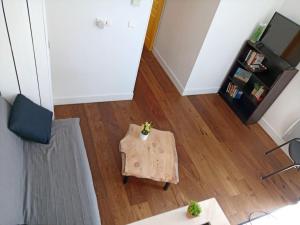 a living room with a table and a tv at Petite maison de charme Les Chats Pîtres in La Rochette