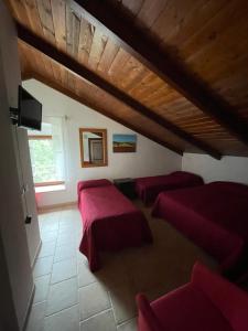 a attic room with two beds and a couch at Rifugio Sfilzi - Foresta Umbra in Vico del Gargano