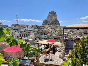 vistas a una ciudad con una montaña en el fondo en Hezen Cave Hotel, en Ortahisar