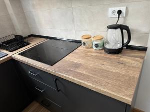 a kitchen counter with a coffee pot and two jars at Apartman Pavlović in Soko Banja
