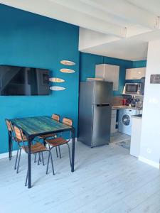 La cuisine est équipée d'une table, de chaises et d'un réfrigérateur. dans l'établissement Cozy Pontaillac, à Vaux-sur-Mer