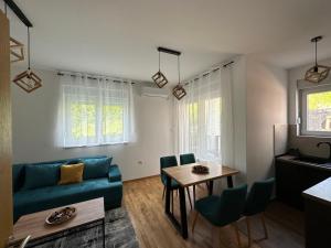 a living room with a blue couch and a table at Apartman Pavlović in Soko Banja