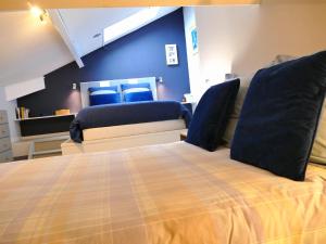 - une chambre avec un lit aux murs bleus dans l'établissement Cozy Pontaillac, à Vaux-sur-Mer