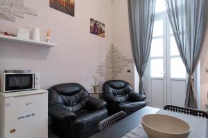 a living room with two black leather chairs and a table at Near Campus& Center: Teeny Tiny in Turin