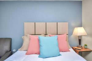 a bedroom with a bed with pink and blue pillows at Studio Apt: Heart of Houston in Houston