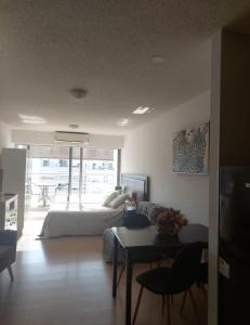 ein Wohnzimmer mit einem Sofa und einem Tisch mit einem Tisch in der Unterkunft Edificio Go Pocitos in Montevideo