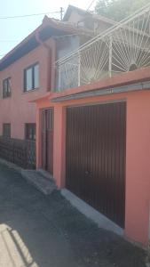 une maison rose avec une porte devant elle dans l'établissement Oaza Mira, à Sarajevo