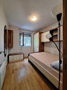 une chambre avec un lit et une lampe dedans dans l'établissement Ljiljana, à Petrovac na Moru