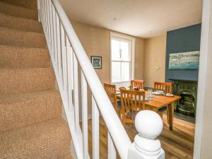 uma cozinha e sala de jantar com uma mesa e escadas em Leo's Place em Weymouth
