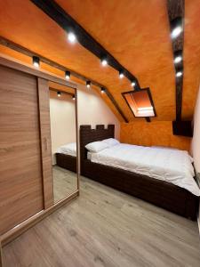 a bedroom with two beds and a mirror at Motel pizzeria Actros in Nova Topola