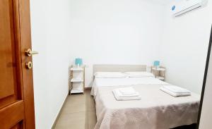 トルトリにあるBivano Faro Bellavistaの白いシーツとタオル付きのベッドが備わる小さな客室です。