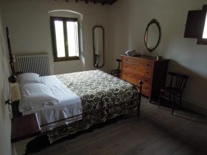 Schlafzimmer mit einem Bett, einer Kommode und einem Spiegel in der Unterkunft La Turra - Casa di Campagna in Greve in Chianti