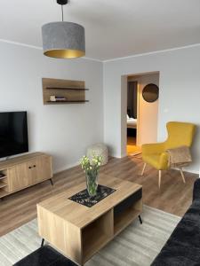 a living room with a couch and a tv and a table at Apartament Centrum II in Lidzbark Warmiński