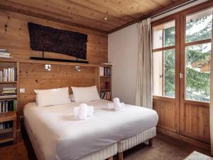 una camera da letto con un letto grande con cuscini bianchi di Chalet Chaleureux à Méribel : Cheminée, Jacuzzi, Proche Commerces, 4 Chambres en Suite - FR-1-688-18 a Méribel