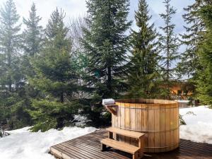 una vasca di legno appoggiata su un ponte di legno nella neve di Chalet Chaleureux à Méribel : Cheminée, Jacuzzi, Proche Commerces, 4 Chambres en Suite - FR-1-688-18 a Méribel