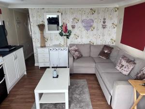 a living room with a couch and a table at Chalet 71 in Leysdown-on-Sea