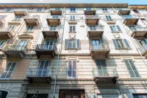 un grand bâtiment avec des fenêtres et des balcons. dans l'établissement Near Campus& Center: Teeny Tiny, à Turin