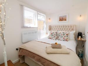 a white bedroom with a large bed with a large window at Garden Suite in Dronfield