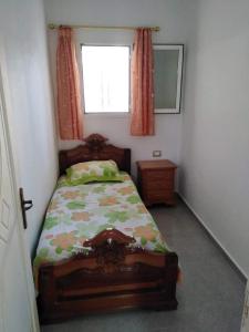a small bedroom with a bed and a window at Maison Ben Cheikh in Kelibia
