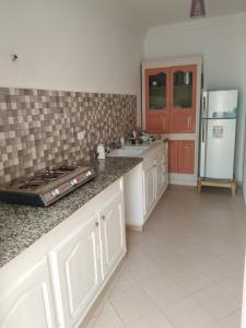 a kitchen with a sink and a refrigerator at Maison Ben Cheikh in Kelibia +10 photos