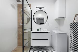 Elite Apartments Chlebova Premium في غدانسك: حمام أبيض مع حوض ومرآة