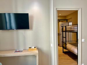 a living room with a television and a bunk bed at Le Five Tellier - Monkey in Reims