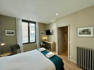 Schlafzimmer mit einem Bett, einem Schreibtisch und einem Fenster in der Unterkunft Le Five Tellier - Monkey in Reims