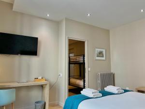 a room with a bed and a flat screen tv at Le Five Tellier - Monkey in Reims