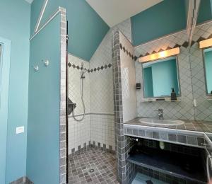 ein Bad mit einem Waschbecken und einem Spiegel in der Unterkunft Le Five Tellier - Monkey in Reims
