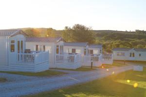 a row of white homes in a row at Meadow Lakes Holiday Park in Grampound